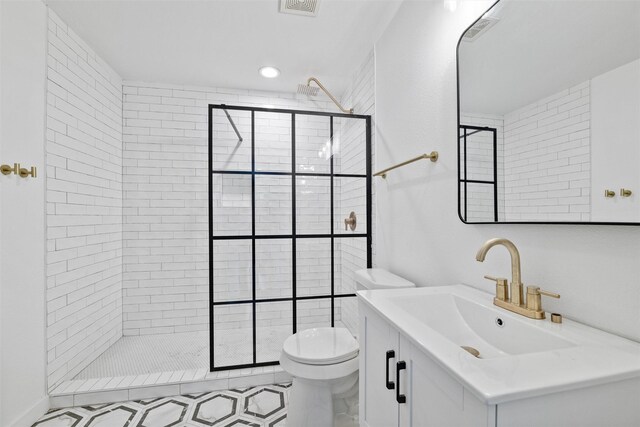 bathroom with vanity, visible vents, toilet, tiled shower, and recessed lighting