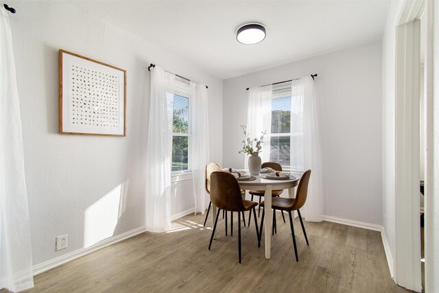 dining area featuring baseboards, plenty of natural light, and wood finished floors