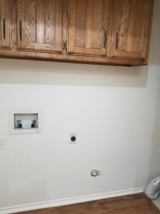 washroom with washer hookup, hookup for an electric dryer, cabinet space, wood finished floors, and baseboards