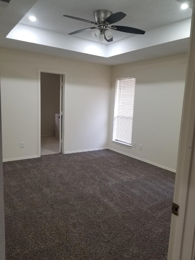 carpeted spare room with baseboards, recessed lighting, a raised ceiling, and ceiling fan