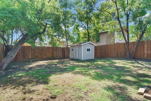 view of yard featuring an outdoor structure, a storage shed, and a fenced backyard