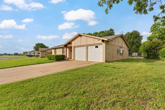 view of front facade with a garage, a front yard, brick siding, board and batten siding, and driveway