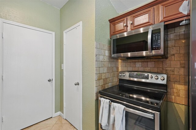 3145 Ronay Dr, Forest Hill, TX 76140 - kitchen with brown cabinetry, stainless steel appliances, and light tile patterned flooring
