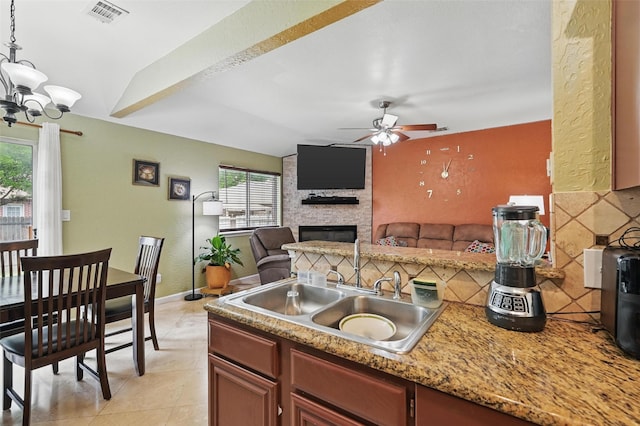 3145 Ronay Dr, Forest Hill, TX 76140 - kitchen featuring hanging light fixtures, ceiling fan with notable chandelier, a sink, a fireplace, and visible vents