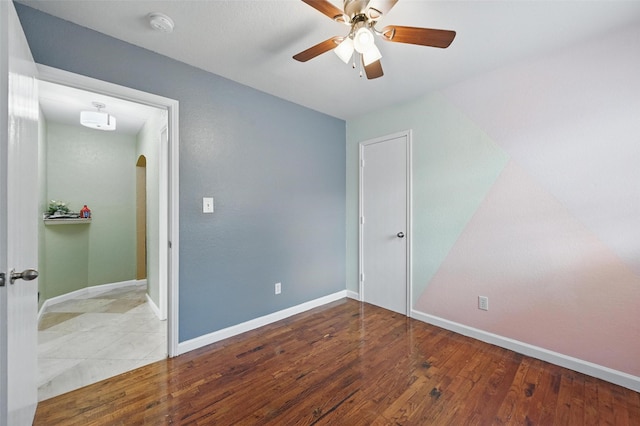 3145 Ronay Dr, Forest Hill, TX 76140 - unfurnished bedroom featuring wood finished floors, baseboards, a ceiling fan, and arched walkways