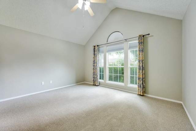 carpeted spare room featuring baseboards, a ceiling fan, and high vaulted ceiling