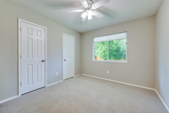 unfurnished bedroom featuring carpet flooring, a textured ceiling, and baseboards