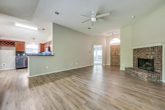 unfurnished living room featuring a healthy amount of sunlight, high vaulted ceiling, ceiling fan, and visible vents