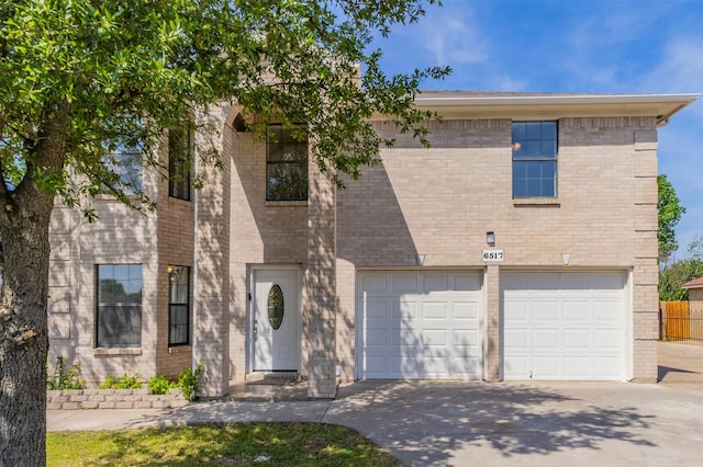 view of front of home featuring a garage, driveway, and brick siding
