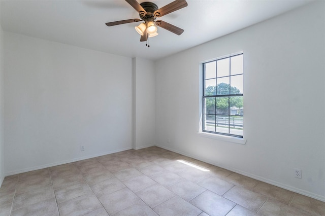 unfurnished room with a ceiling fan, baseboards, and light tile patterned floors