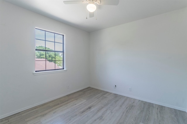 empty room featuring baseboards, ceiling fan, and light wood-style flooring