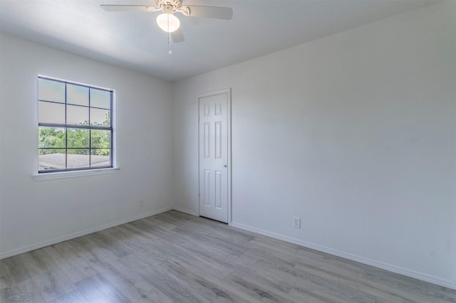empty room featuring baseboards, a ceiling fan, and wood finished floors