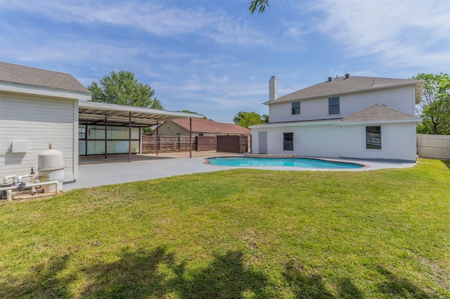 back of house featuring a lawn, a fenced in pool, a fenced backyard, and a patio area