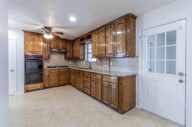 kitchen with ceiling fan, backsplash, a sink, black appliances, and under cabinet range hood