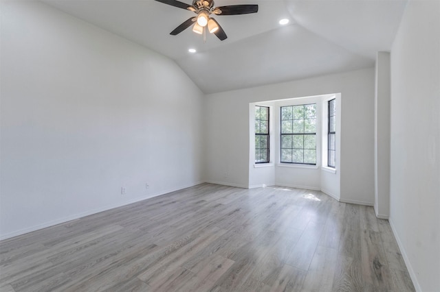 empty room with ceiling fan, light wood-style floors, recessed lighting, baseboards, and lofted ceiling