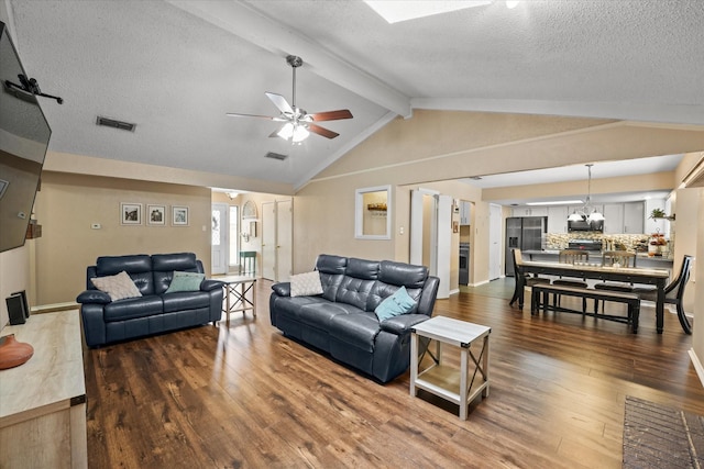 living room featuring a textured ceiling, ceiling fan with notable chandelier, hardwood / wood-style floors, and visible vents