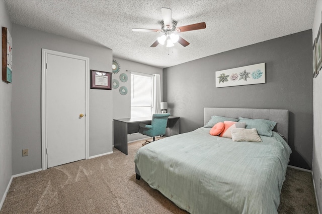 carpeted bedroom with baseboards, ceiling fan, and a textured ceiling