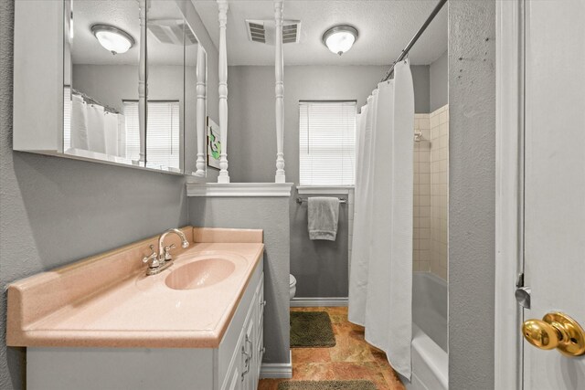 full bath featuring visible vents, a textured ceiling, toilet, and vanity