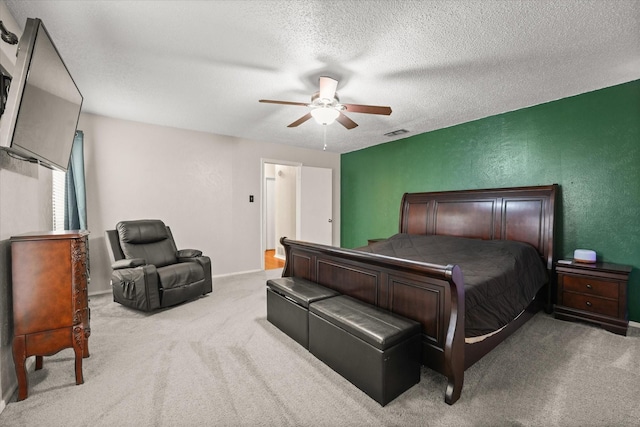 carpeted bedroom featuring visible vents, a textured wall, baseboards, a textured ceiling, and a ceiling fan