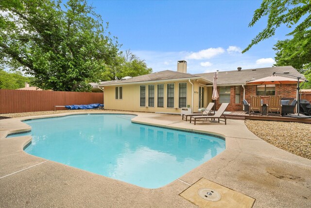 view of swimming pool featuring a fenced in pool, a patio, a fenced backyard, and a deck