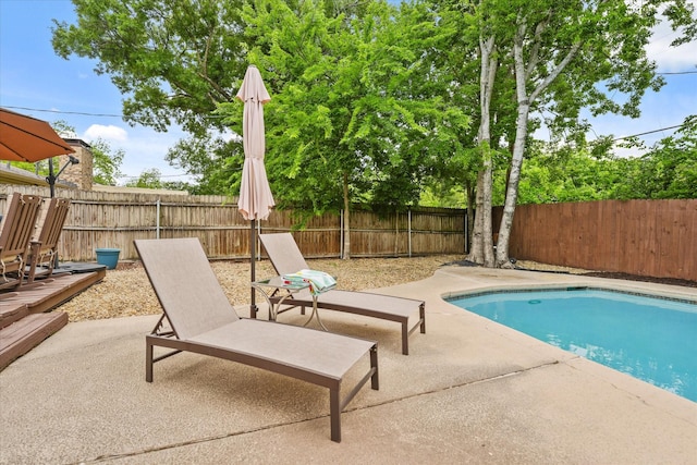 view of swimming pool with a fenced in pool, a fenced backyard, and a patio area