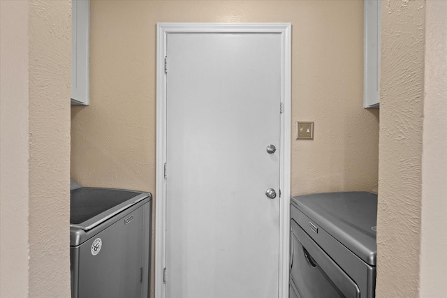 laundry room featuring washer and dryer, laundry area, and a textured wall