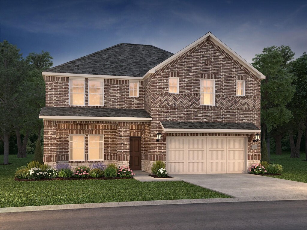 traditional-style house featuring brick siding, an attached garage, driveway, and a front lawn