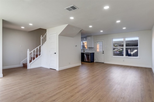 unfurnished living room featuring stairs, recessed lighting, visible vents, and light wood finished floors