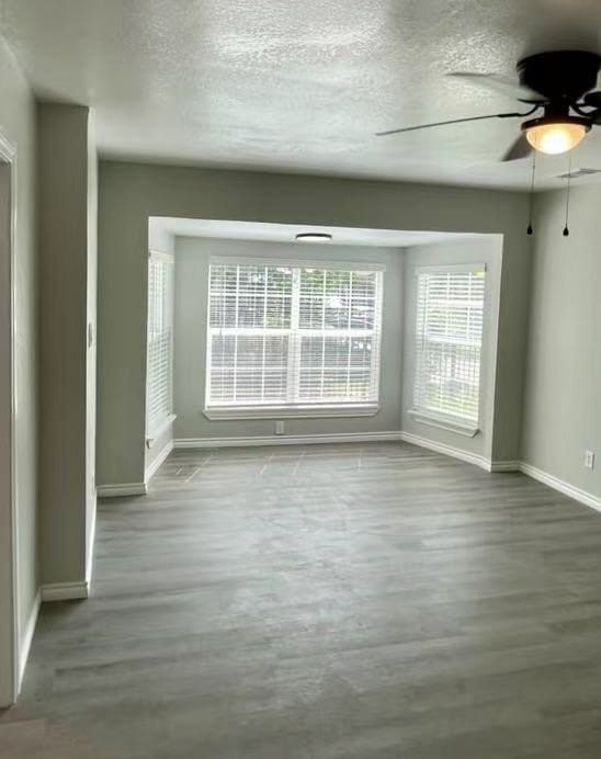 1003 Epenard St, Dallas, TX 75211 - empty room featuring baseboards, a textured ceiling, ceiling fan, and wood finished floors