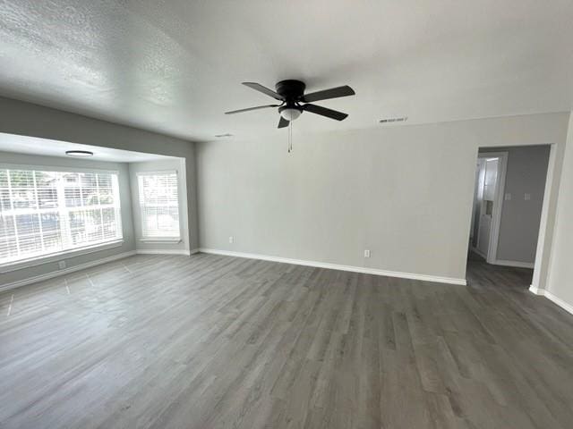 1003 Epenard St, Dallas, TX 75211 - unfurnished living room with ceiling fan, visible vents, baseboards, and wood finished floors