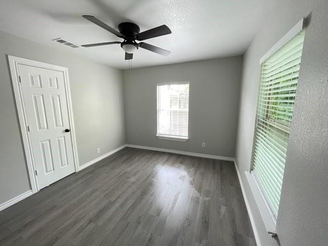 1003 Epenard St, Dallas, TX 75211 - unfurnished bedroom featuring visible vents, baseboards, dark wood-type flooring, and ceiling fan