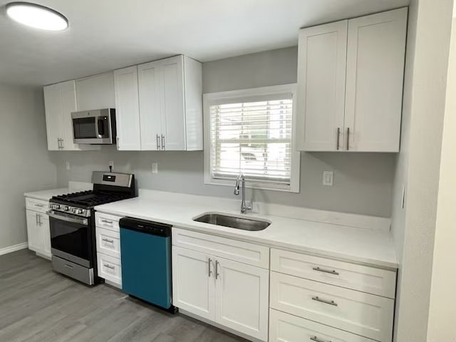 1003 Epenard St, Dallas, TX 75211 - kitchen featuring a sink, appliances with stainless steel finishes, white cabinetry, and light countertops