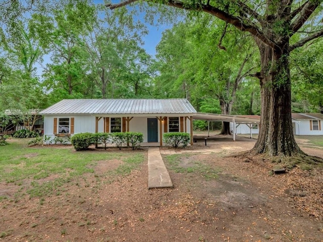 single story home with a carport, covered porch, and metal roof