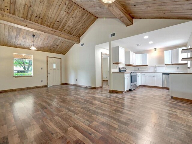 unfurnished living room with visible vents, beamed ceiling, baseboards, dark wood-type flooring, and a sink