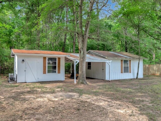 back of house featuring a storage shed, fence, and an outbuilding
