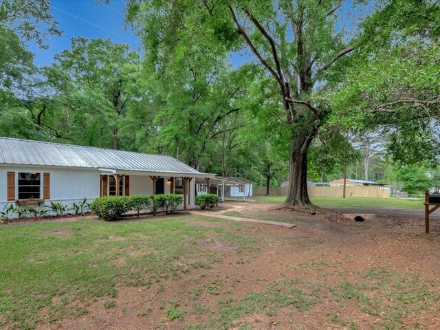 exterior space with a porch, metal roof, and a front yard