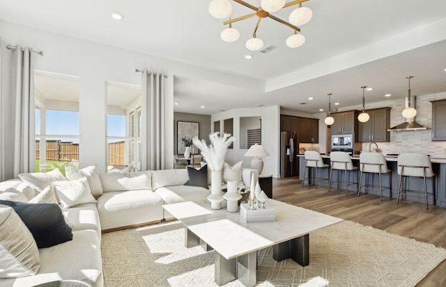 2713 Creekdale Dr, Celina, TX 75009 - living room featuring visible vents, recessed lighting, light wood-style flooring, and an inviting chandelier