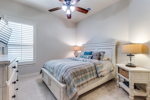 bedroom featuring light colored carpet, a ceiling fan, baseboards, and visible vents