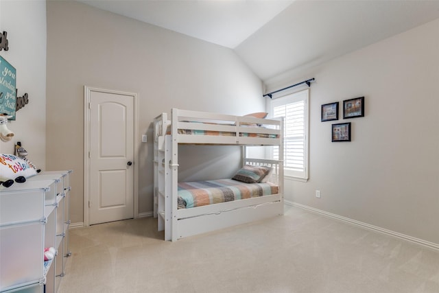 bedroom featuring baseboards, light colored carpet, and lofted ceiling