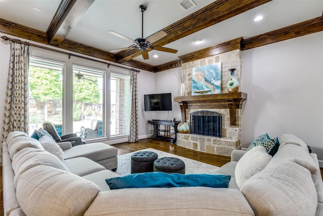 living area with ceiling fan, visible vents, crown molding, wood finished floors, and beam ceiling