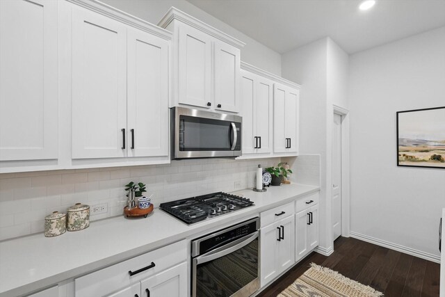 kitchen featuring light countertops, appliances with stainless steel finishes, backsplash, and dark wood finished floors