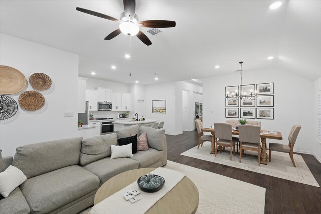 living room with dark wood-style flooring, recessed lighting, visible vents, and ceiling fan with notable chandelier