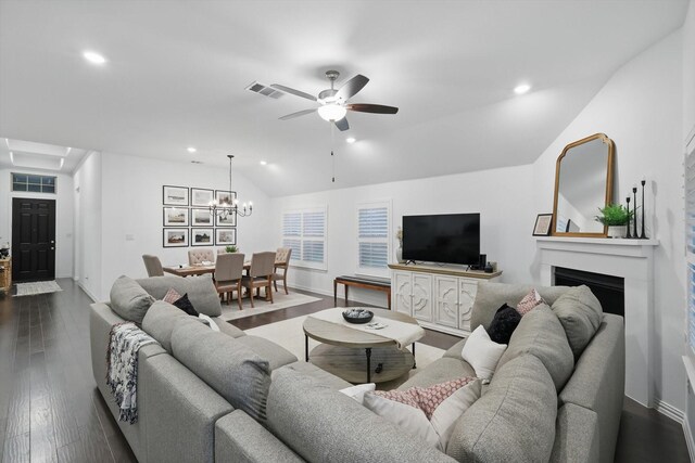 living area with visible vents, a fireplace, vaulted ceiling, ceiling fan with notable chandelier, and recessed lighting