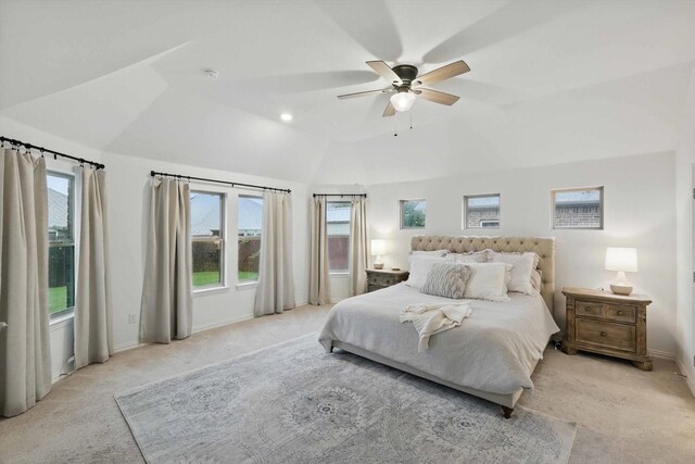 bedroom with vaulted ceiling, light carpet, and multiple windows