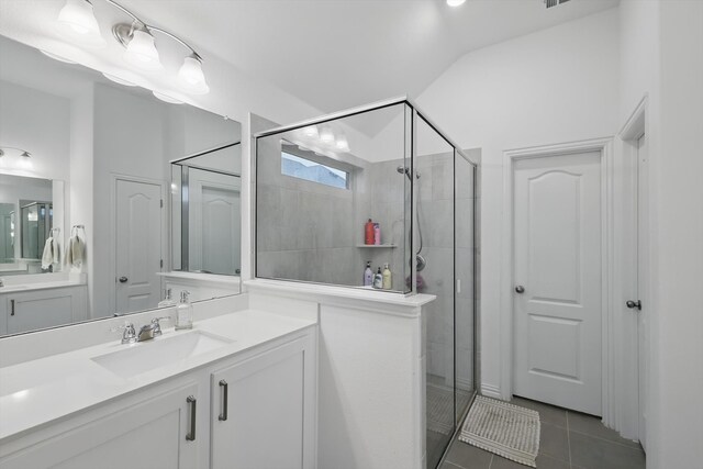 full bathroom featuring vanity, tile patterned floors, lofted ceiling, and a stall shower