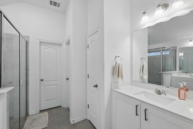 bathroom featuring vanity, tile patterned floors, a shower stall, and visible vents