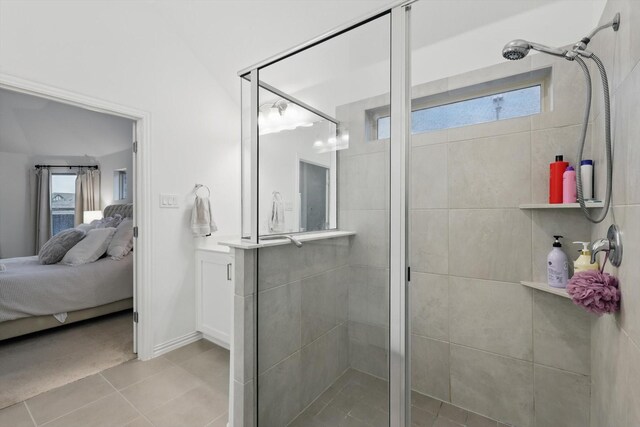 bathroom with ensuite bathroom, tile patterned flooring, and a shower stall