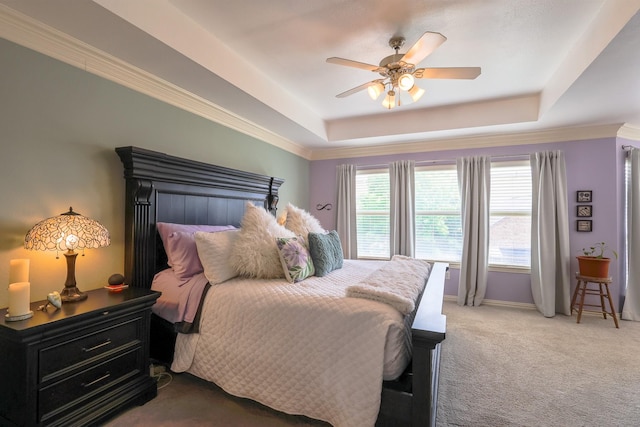 bedroom featuring carpet floors, a raised ceiling, crown molding, and baseboards