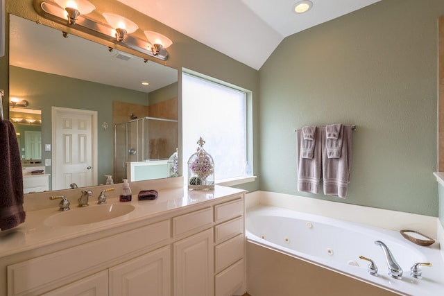 bathroom featuring vanity, a tub with jets, a shower stall, lofted ceiling, and visible vents