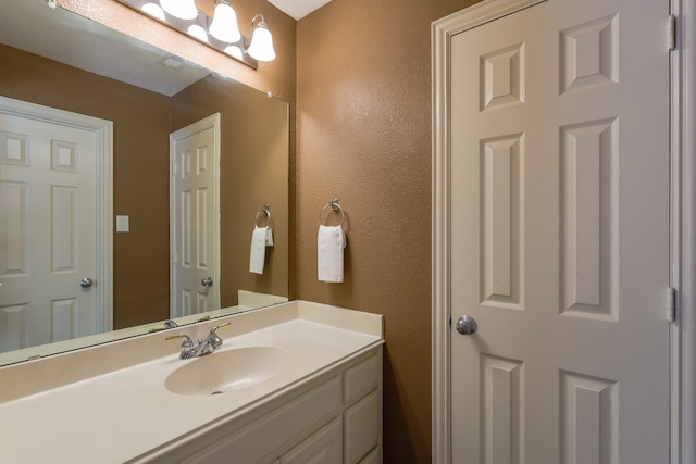 bathroom featuring a textured wall and vanity